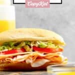 A sub sandwich and homemade Mr. Submarine sub sauce beside it.